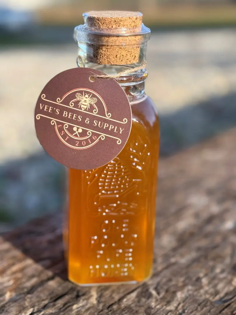 A bottle of honey sitting on top of a table.